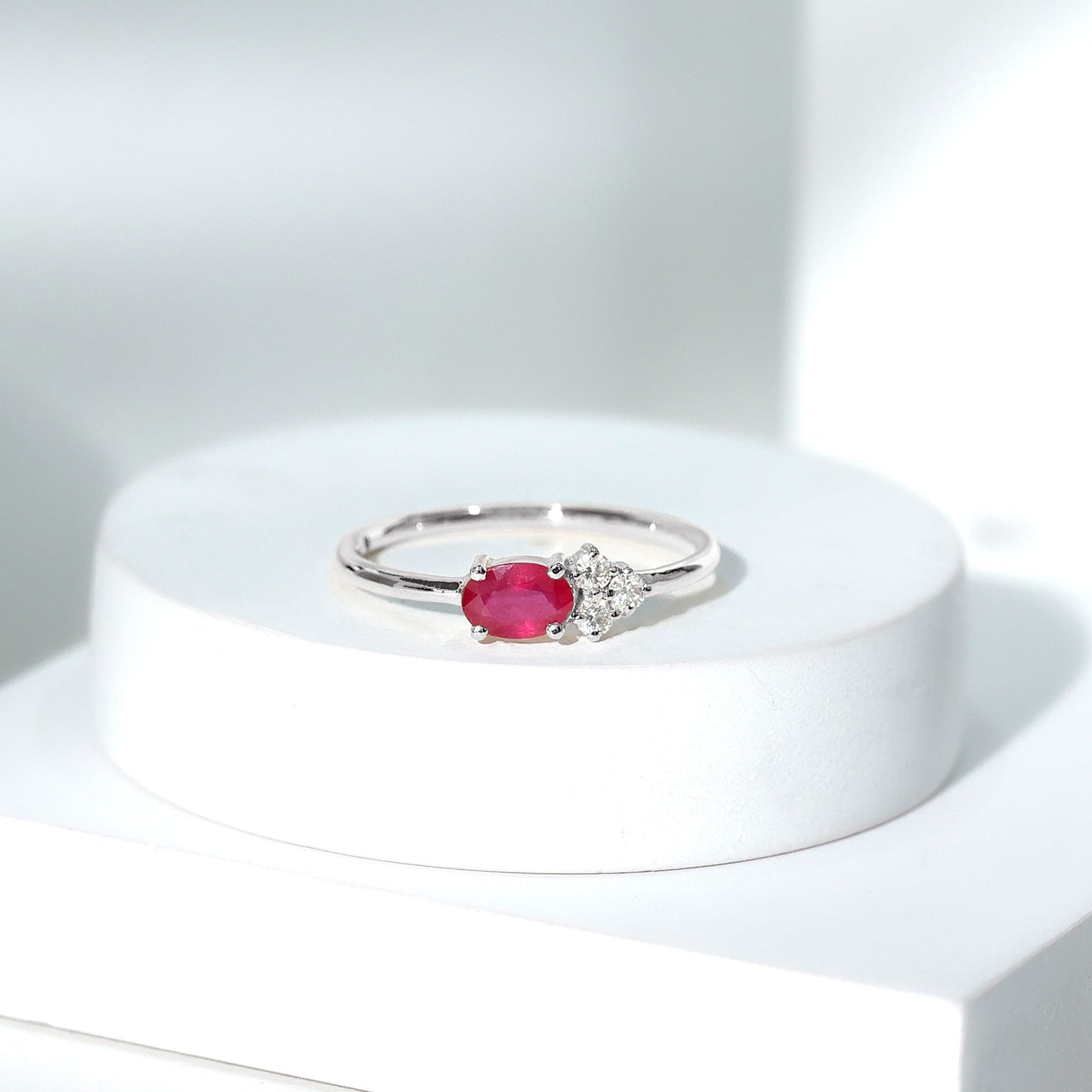 East West Style 0.6 Carat Oval Ruby Promise Ring with Diamond Trio